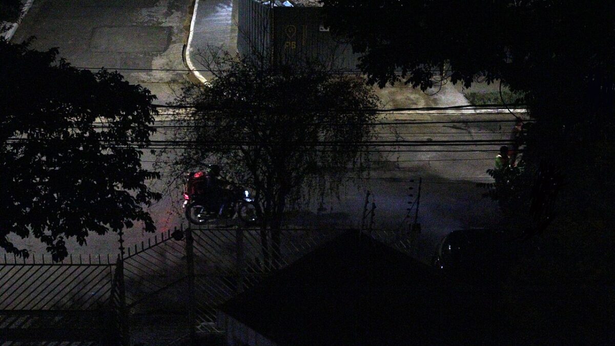 Entregador em motocicleta no trânsito urbano brasileiro.
