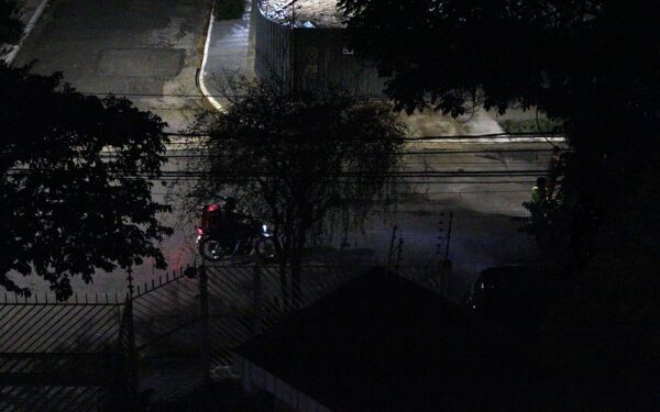 Entregador em motocicleta no trânsito urbano brasileiro.