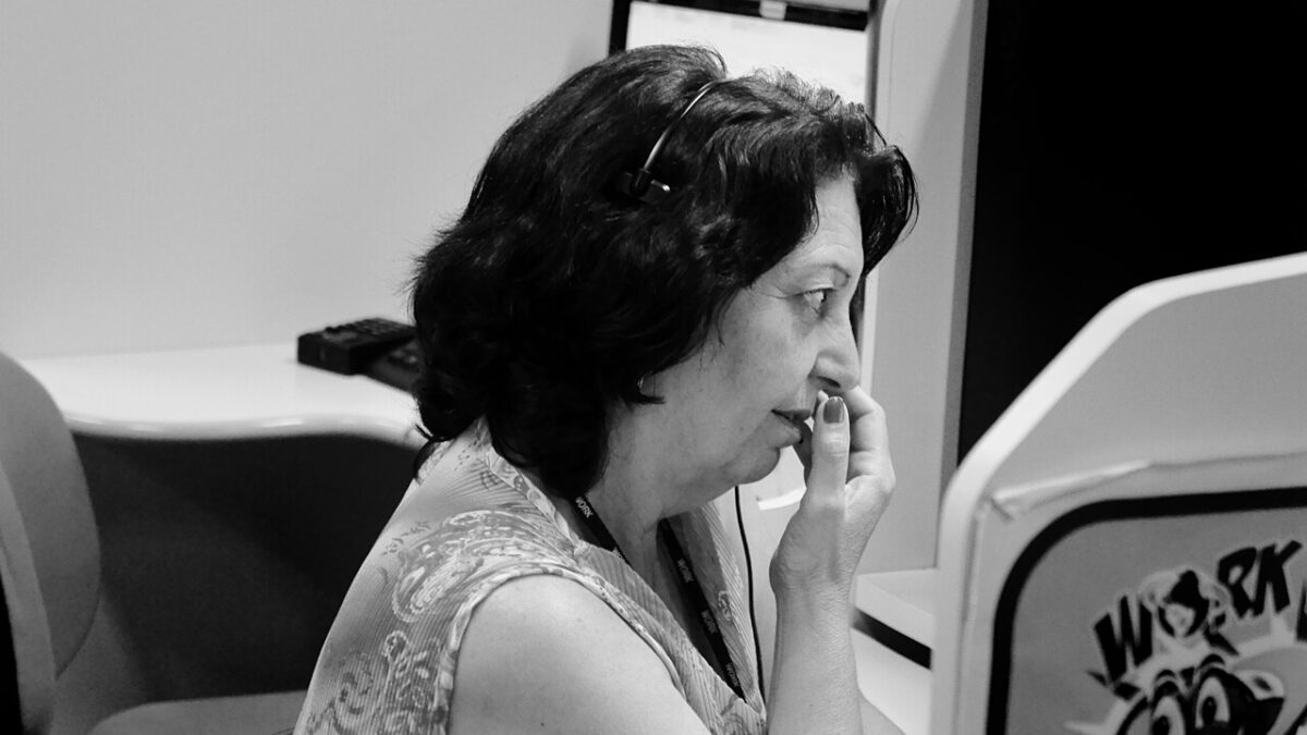 Trabalhadores em estação de call center em ambiente corporativo.