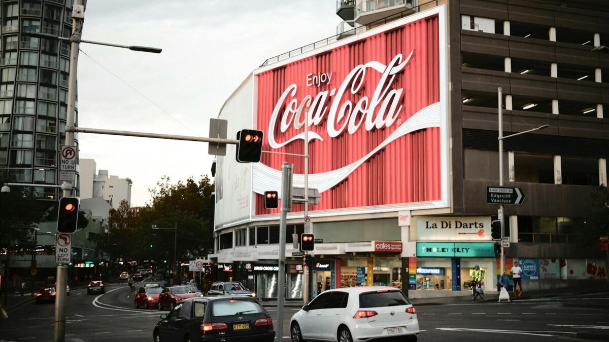 Sydney's famous Coca-Cola billboard lights up a busy street corner.