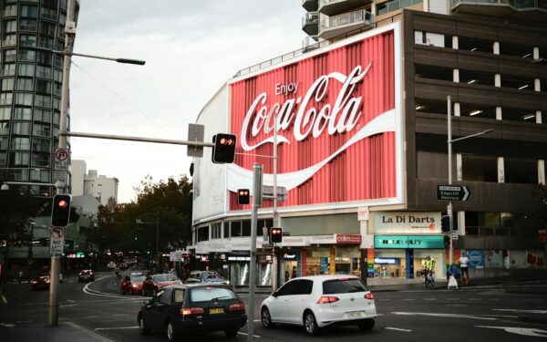 Sydney's famous Coca-Cola billboard lights up a busy street corner.