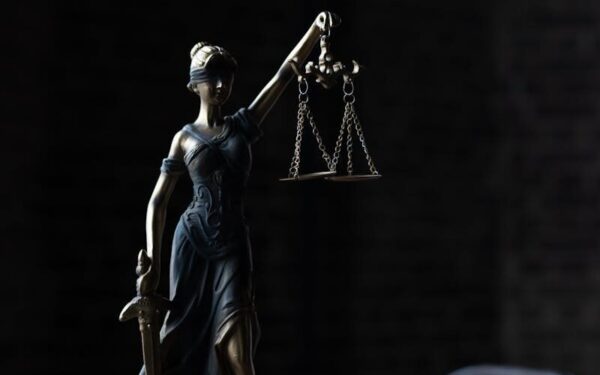 Dramatic lighting on Lady Justice figurine, symbolizing law and fairness.