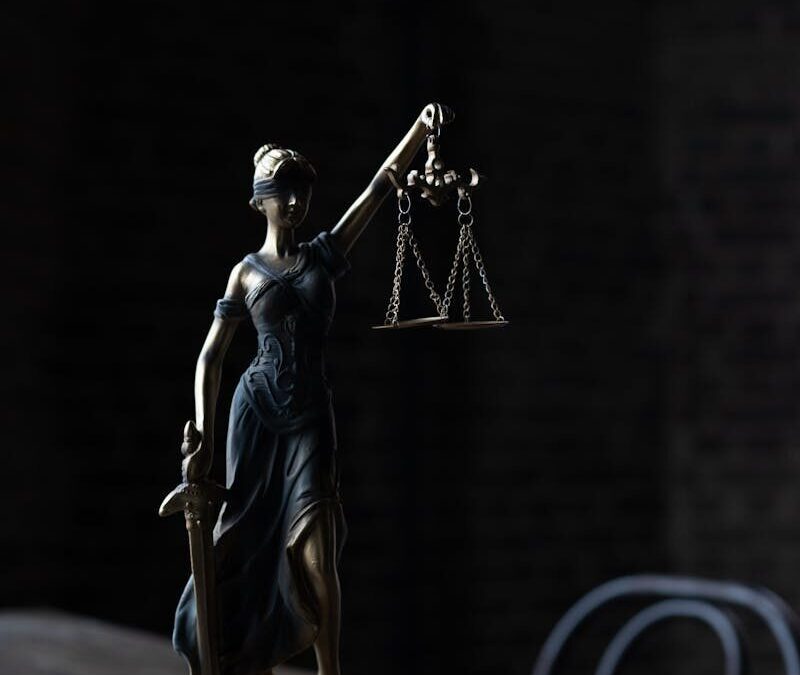Dramatic lighting on Lady Justice figurine, symbolizing law and fairness.